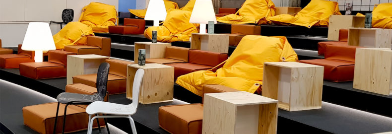 A Grid Mordor-space lounge area with yellow fatboy chairs and white lamps.